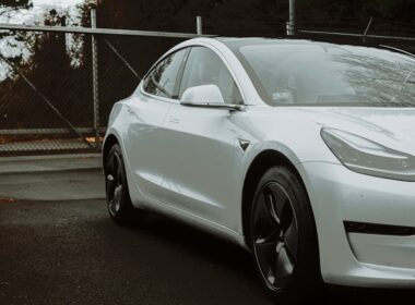 a white car parked in front of a fence