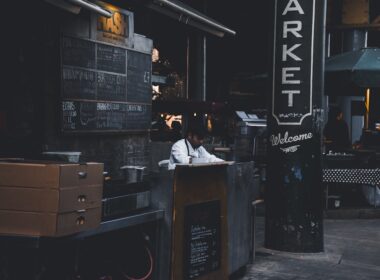a man sitting at a counter in front of a market