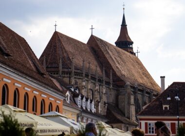 a group of people walking down a street next to tall buildings