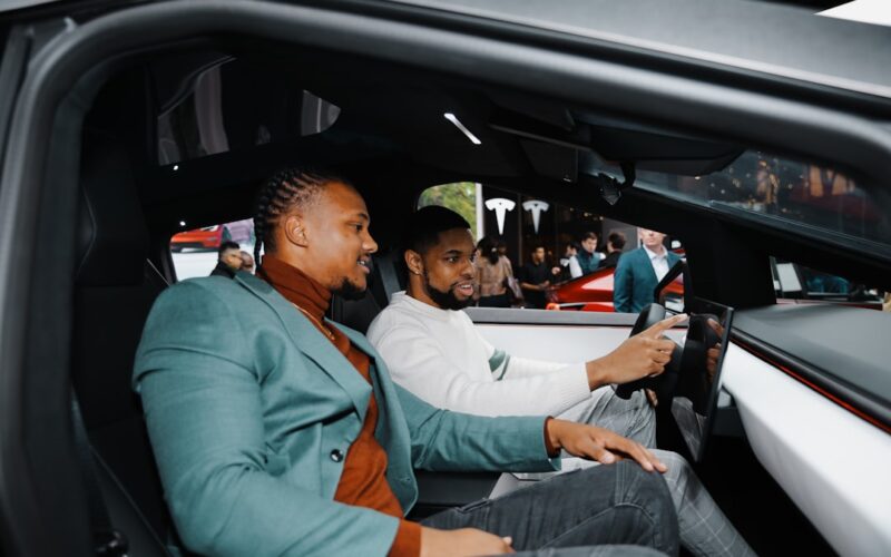 A couple of men sitting in the back of a car