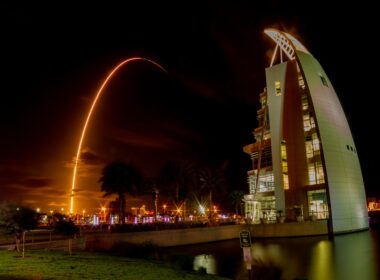 urban photo of a white building by a lake
