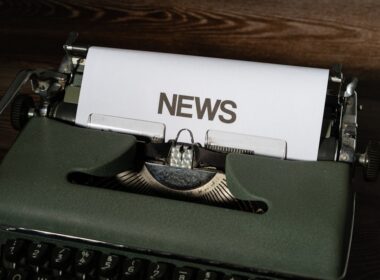 a close up of a typewriter with news paper on it