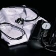 black and silver stethoscope on white textile