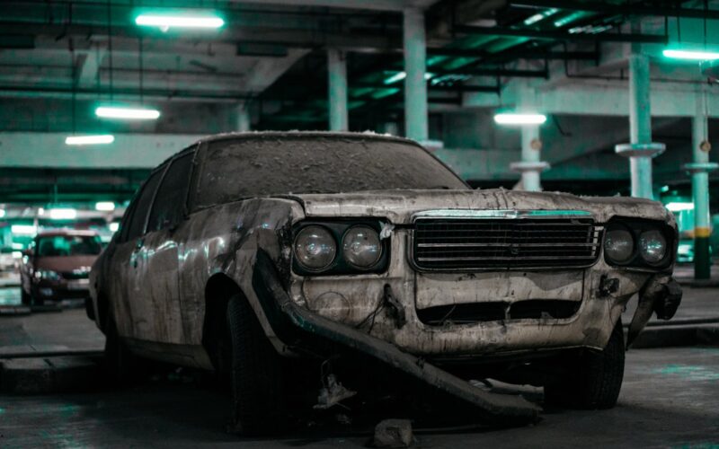 unwashed white sedan parked inside building's parking lto