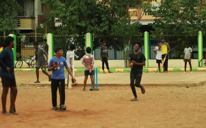a group of people playing a game of cricket