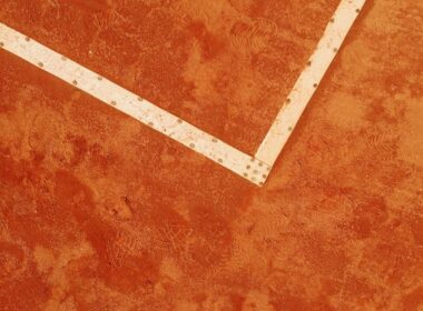 a tennis racket laying on a tennis court