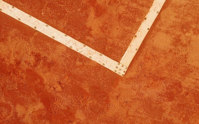 a tennis racket laying on a tennis court