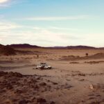 a truck is driving through a desert area