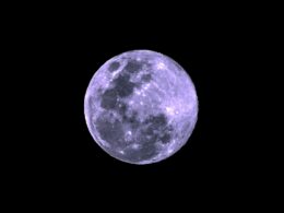 a full moon is seen in the dark sky