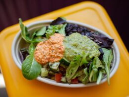 a bowl of salad on a yellow table