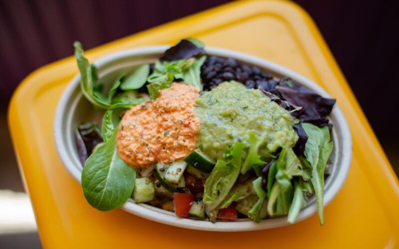 a bowl of salad on a yellow table