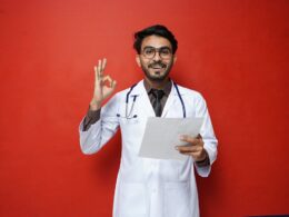 a man in a white coat holding a piece of paper