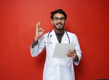 a man in a white coat holding a piece of paper