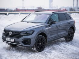 A gray volkswagen touareg parked on a snowy surface.