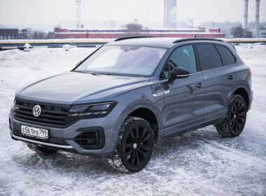 A gray volkswagen touareg parked on a snowy surface.