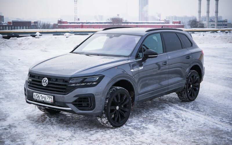 A gray volkswagen touareg parked on a snowy surface.