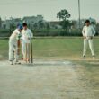a group of men playing a game of cricket