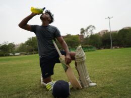 man in black t-shirt and brown pants holding golf club