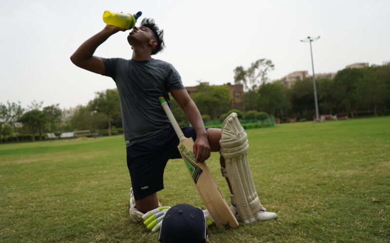 man in black t-shirt and brown pants holding golf club