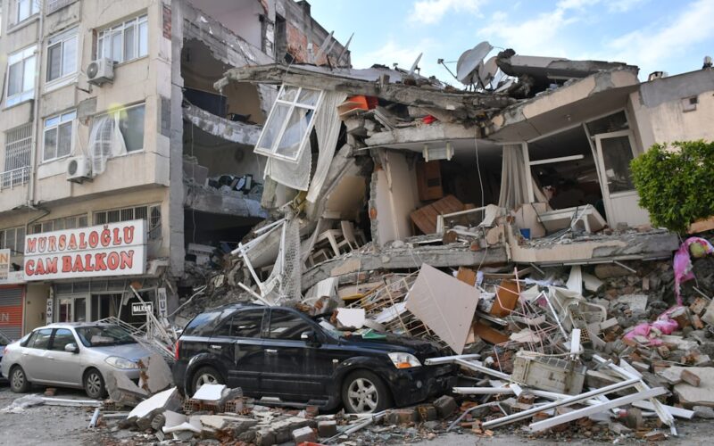 a car is parked in front of a destroyed building