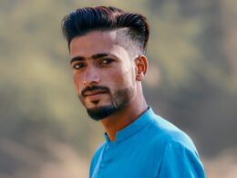 a man in a blue shirt looking at the camera