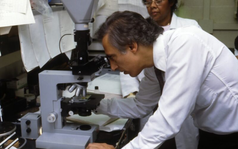 man using microscope