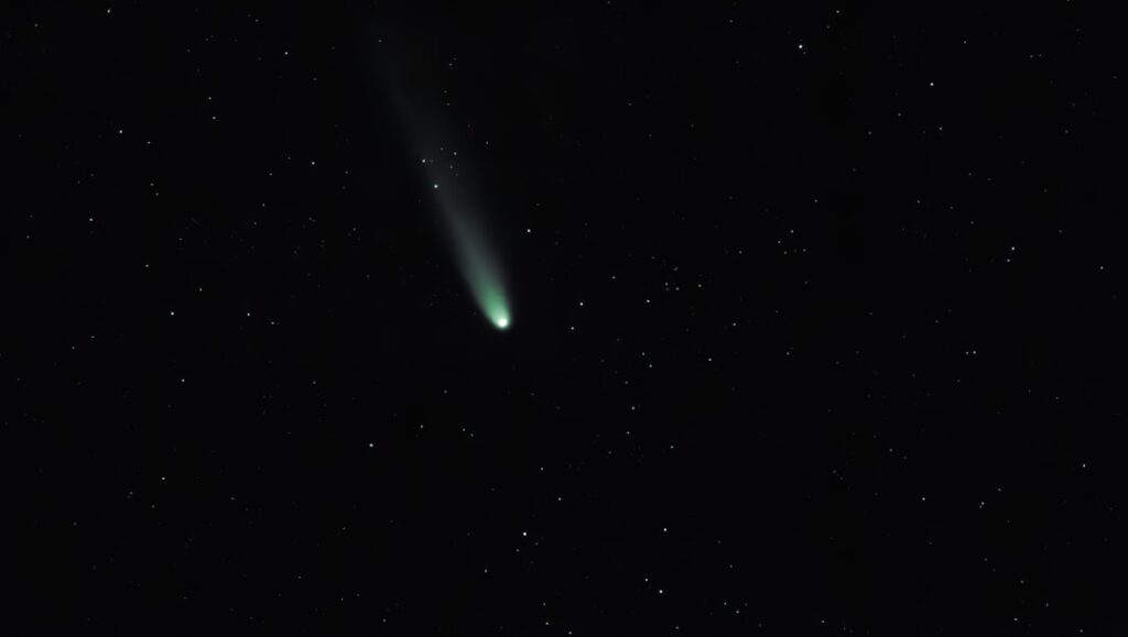 A bright comet with a long tail in starry sky