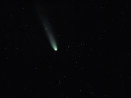 A bright comet with a long tail in starry sky