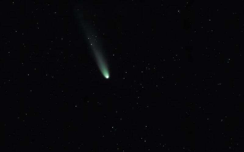 A bright comet with a long tail in starry sky