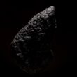 a piece of black rock on a black background