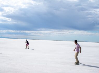 A couple of people riding skis across a snow covered field