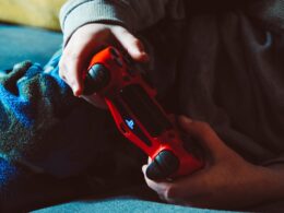 person holding red playstation 4 controller