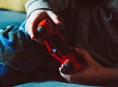 person holding red playstation 4 controller