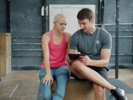 Man and woman looking at tablet in gym