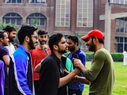 a group of men standing next to each other in front of a building