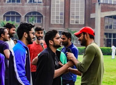 a group of men standing next to each other in front of a building