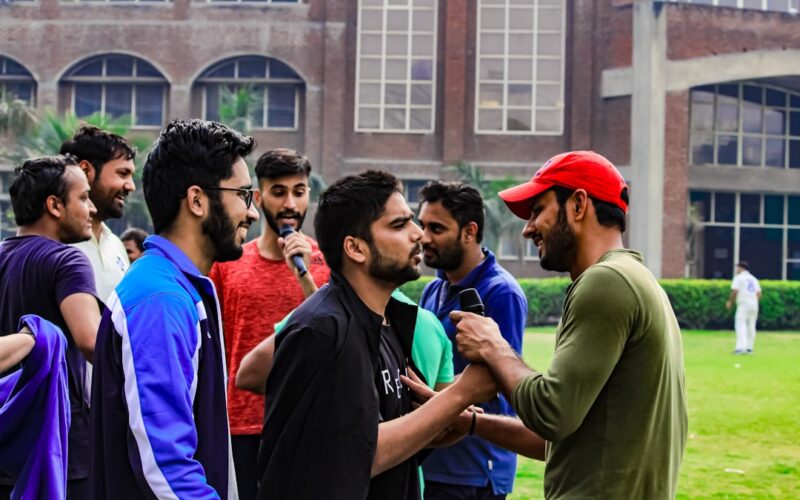 a group of men standing next to each other in front of a building