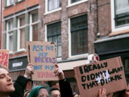 woman holding blue and white wooden signage