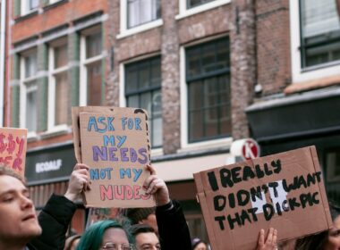 woman holding blue and white wooden signage