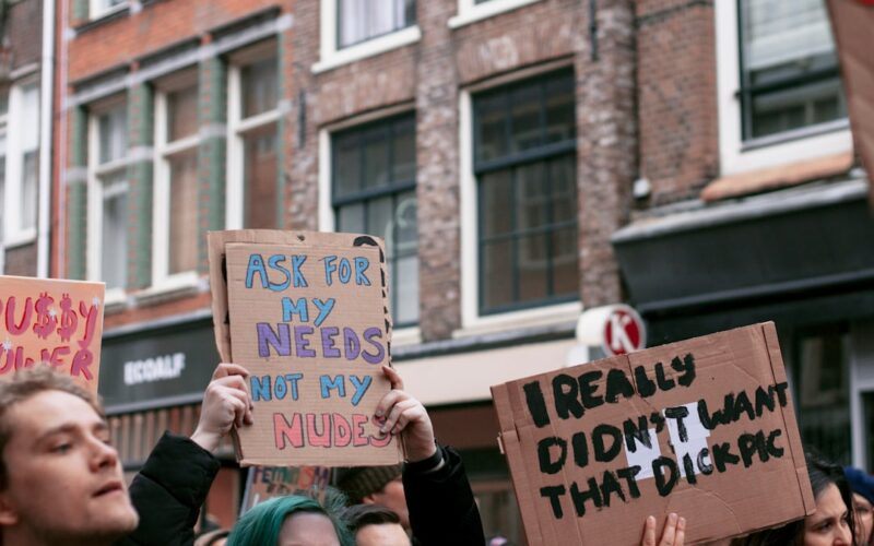 woman holding blue and white wooden signage