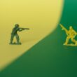 a toy soldier holding a gun next to a toy soldier