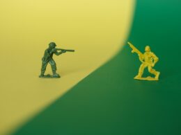 a toy soldier holding a gun next to a toy soldier