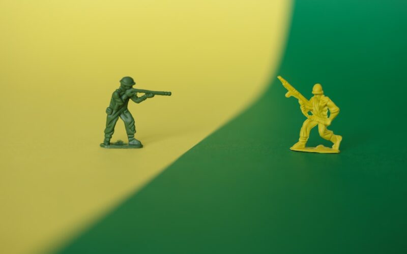 a toy soldier holding a gun next to a toy soldier