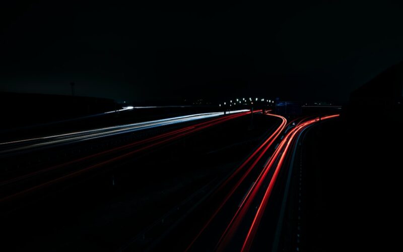 a long exposure photo of a highway at night