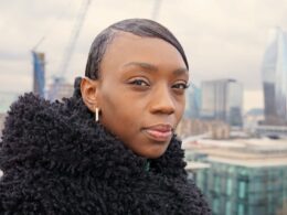 a woman in a black coat looking at the camera