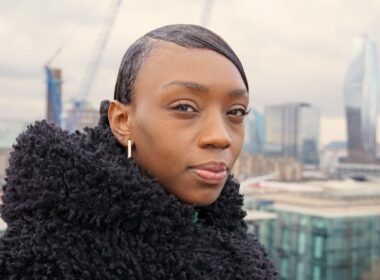 a woman in a black coat looking at the camera