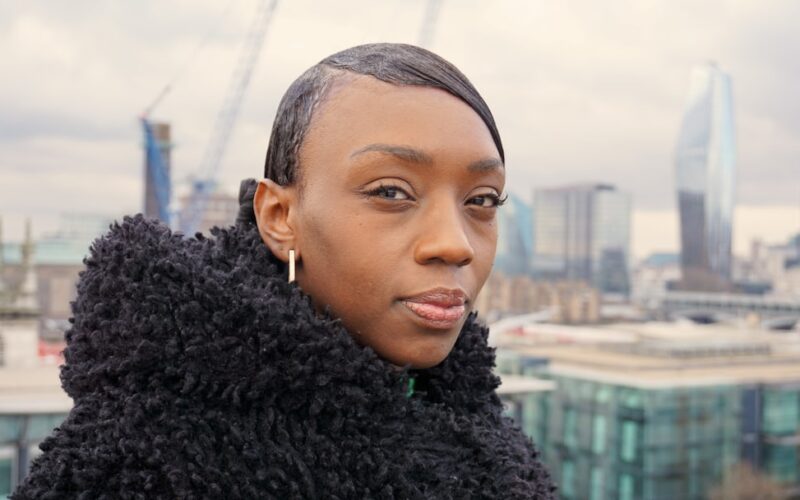 a woman in a black coat looking at the camera