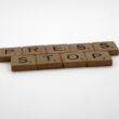 a set of wooden blocks spelling press and stop
