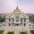 Grand ornate building with golden dome and city background