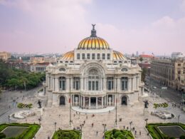 Grand ornate building with golden dome and city background